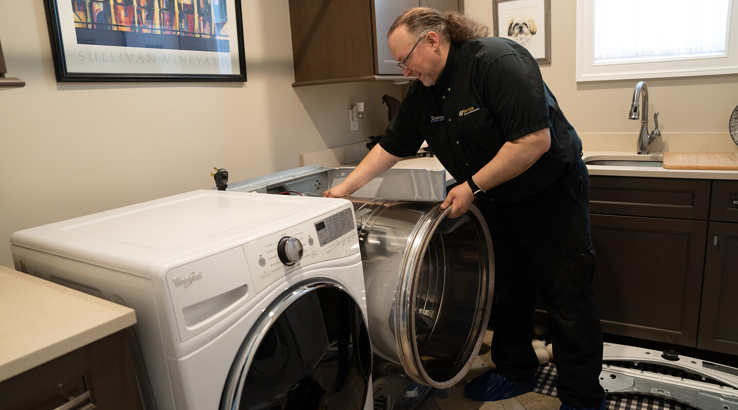 A technician working on a dryer A technician working on a dryer