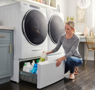 Person opening the drawer of a laundry pedestal