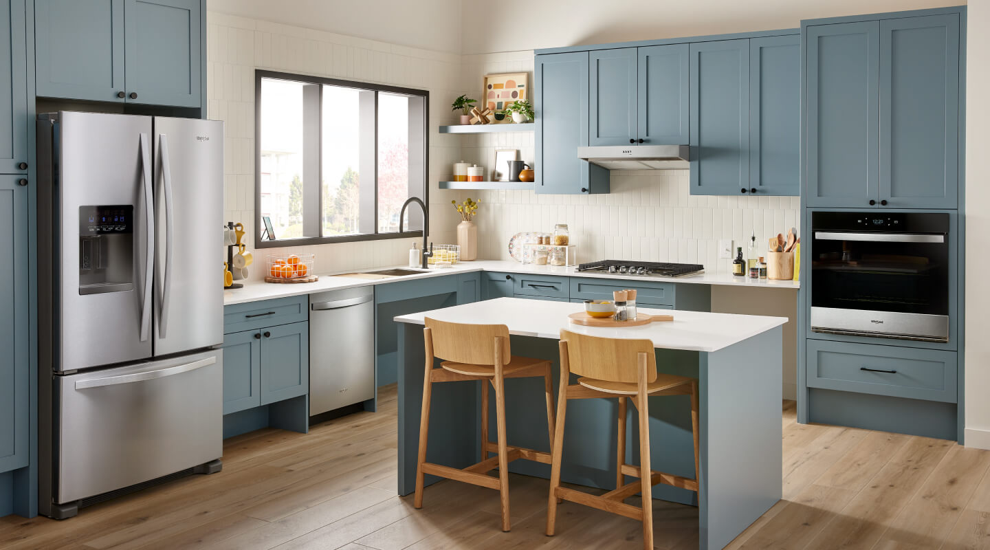 Stainless steel appliances in a blue kitchen