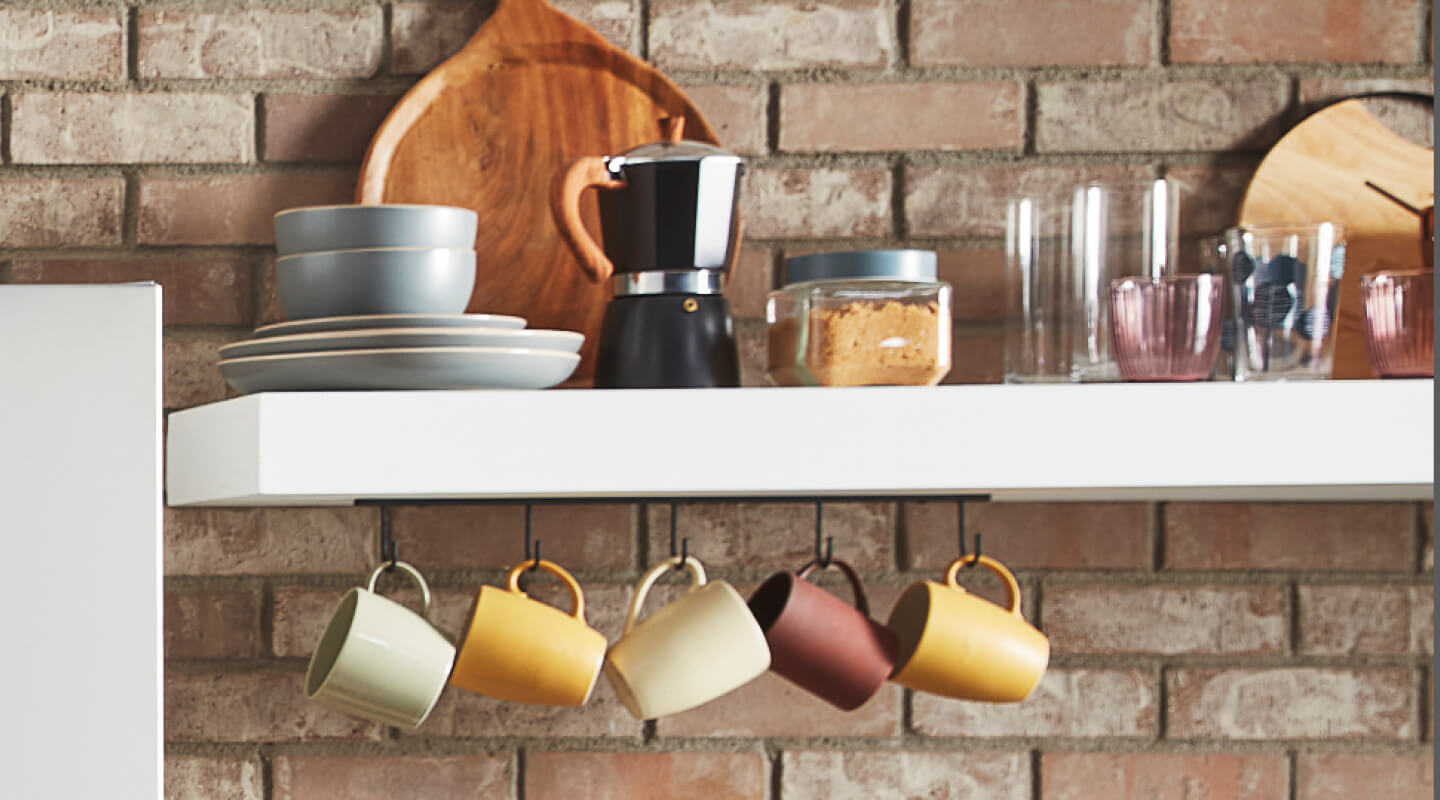 White shelves filled with mugs and coffee accessories