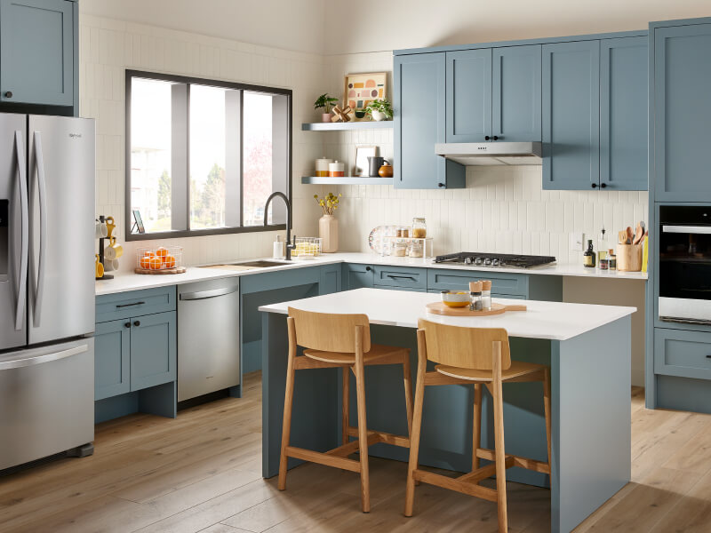 Stainless steel appliances in a blue kitchen