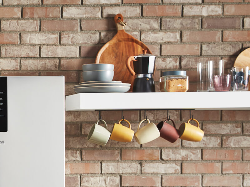 White shelves filled with mugs and coffee accessories