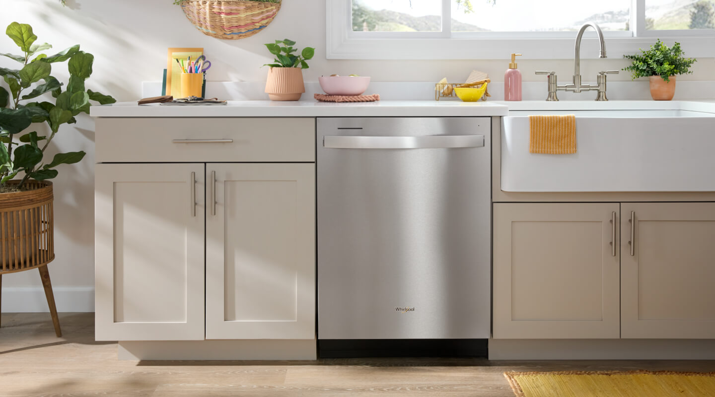  A stainless steel dishwasher in a kitchen with beige cabinetry