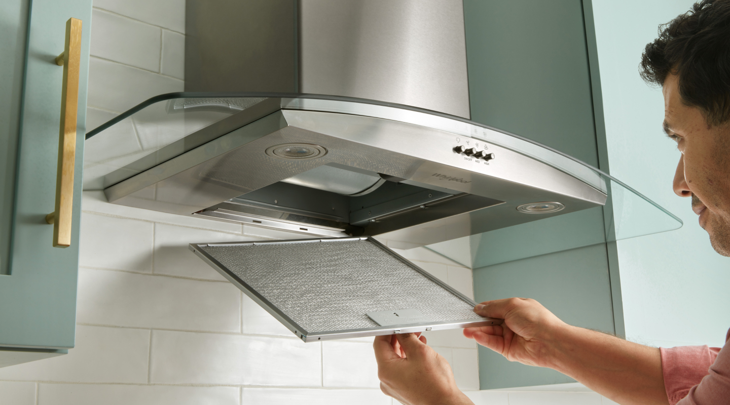 Person removing range hood filter Person removing range hood filter