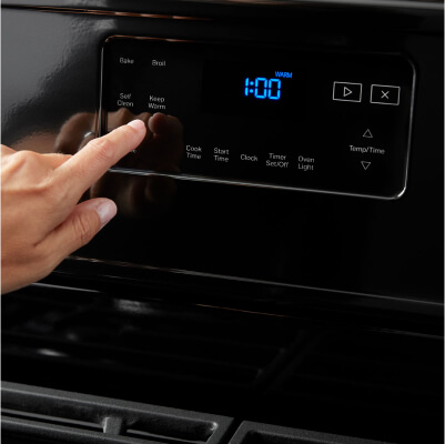 A person making a selection on a self-cleaning range