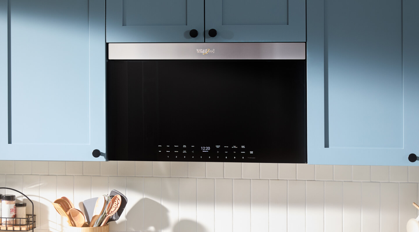 Whirlpool® Over-the-Range Microwave Oven against blue cabinetry