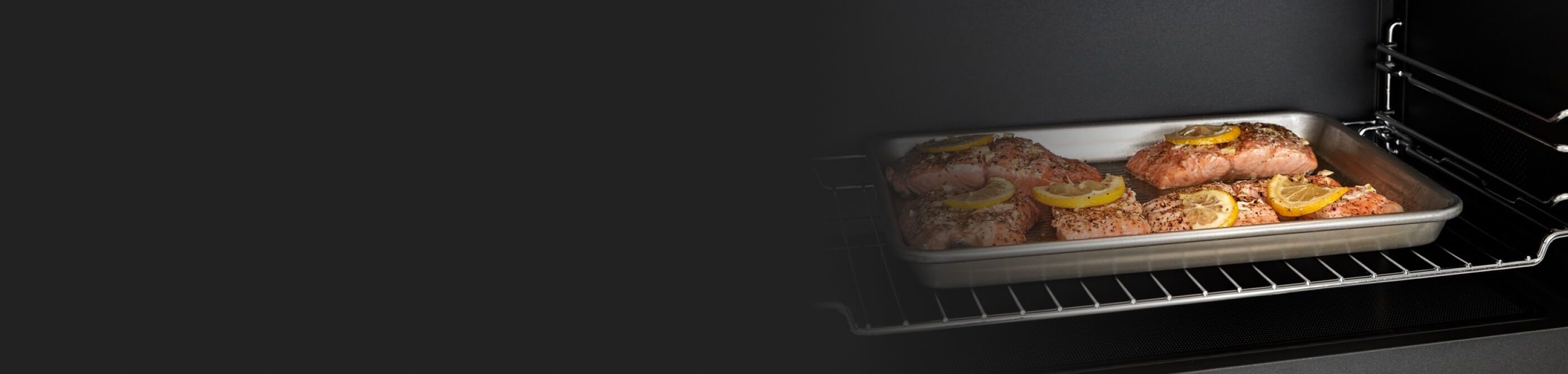 Salmon filets on a sheet pan inside a microwave