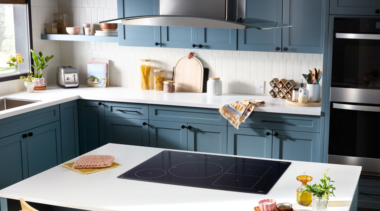 The inside of a kitchen with an induction cooktop in a kitchen island