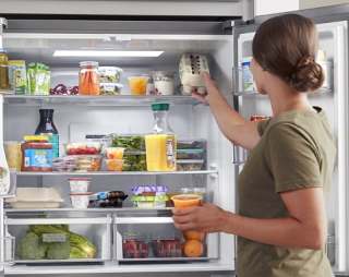 Person loading food into a refrigerator