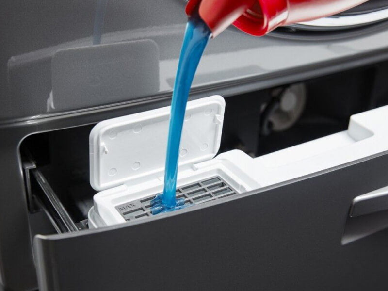 Blue HE detergent flowing into a dispenser