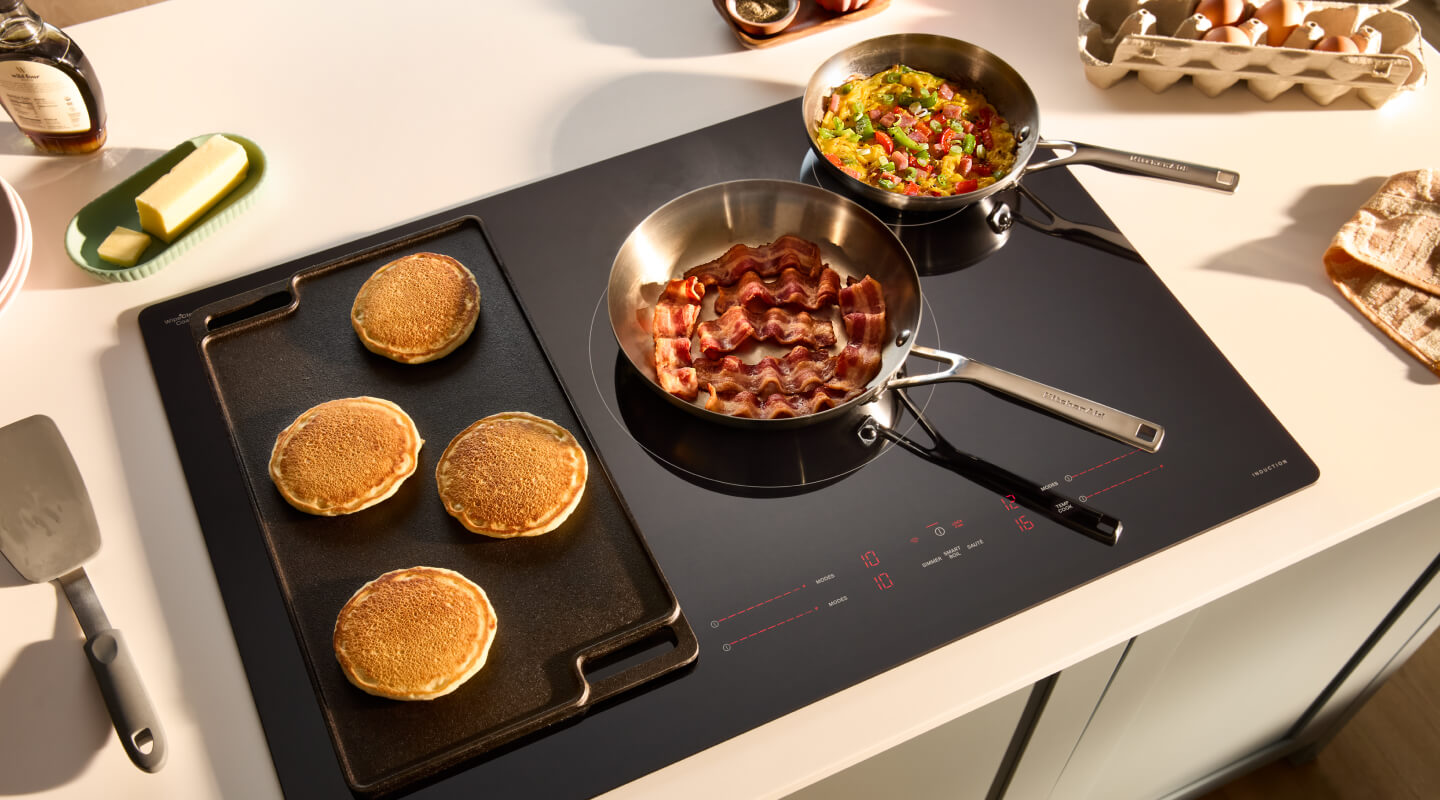 Pancakes and bacon cooking on an induction cooktop