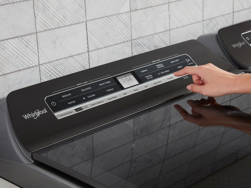 A person selects a laundry cycle from a touchpad A person selects a laundry cycle from a touchpad