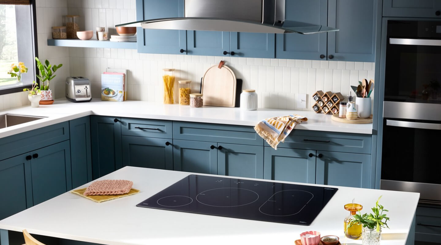 A bright, modern kitchen with white countertops and blue cabinetry