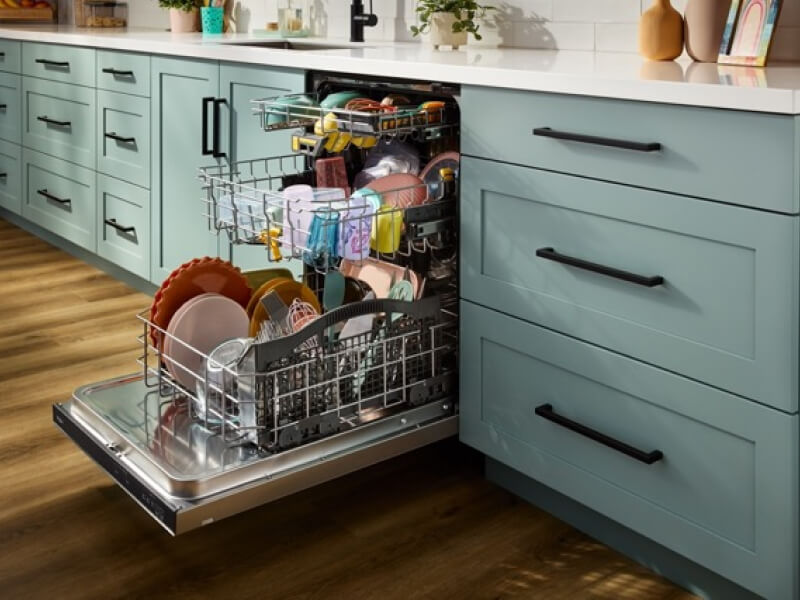 A dishwasher open with racks of clean dishes pulled out