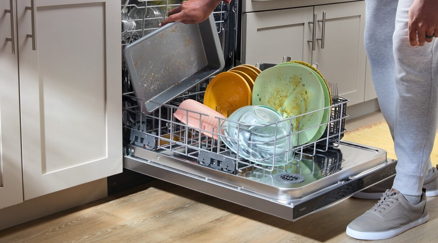 A person putting dirty dishes in a dishwasher