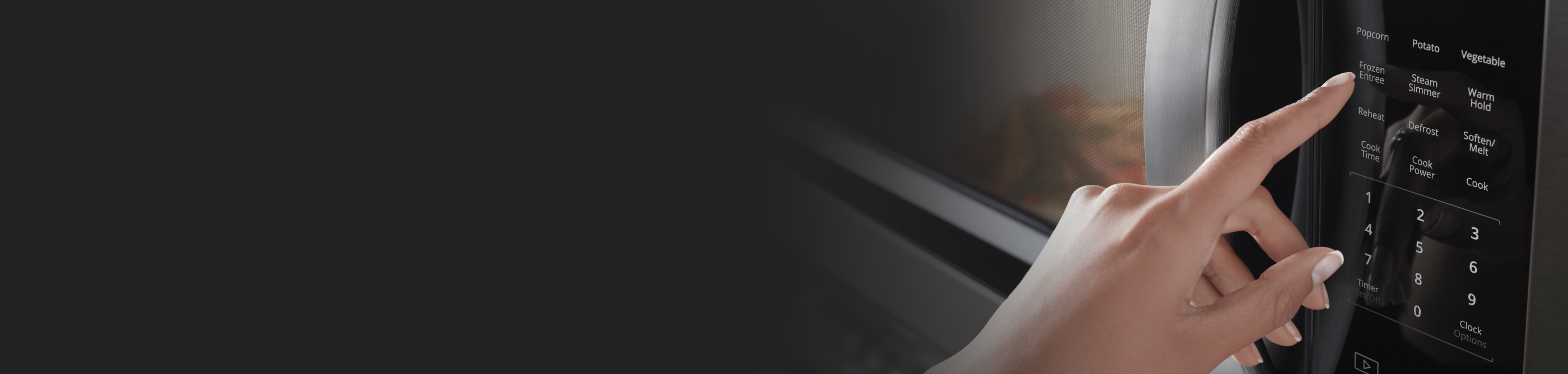 A closeup of a person’s hand programming a setting on a Whirlpool® microwave.