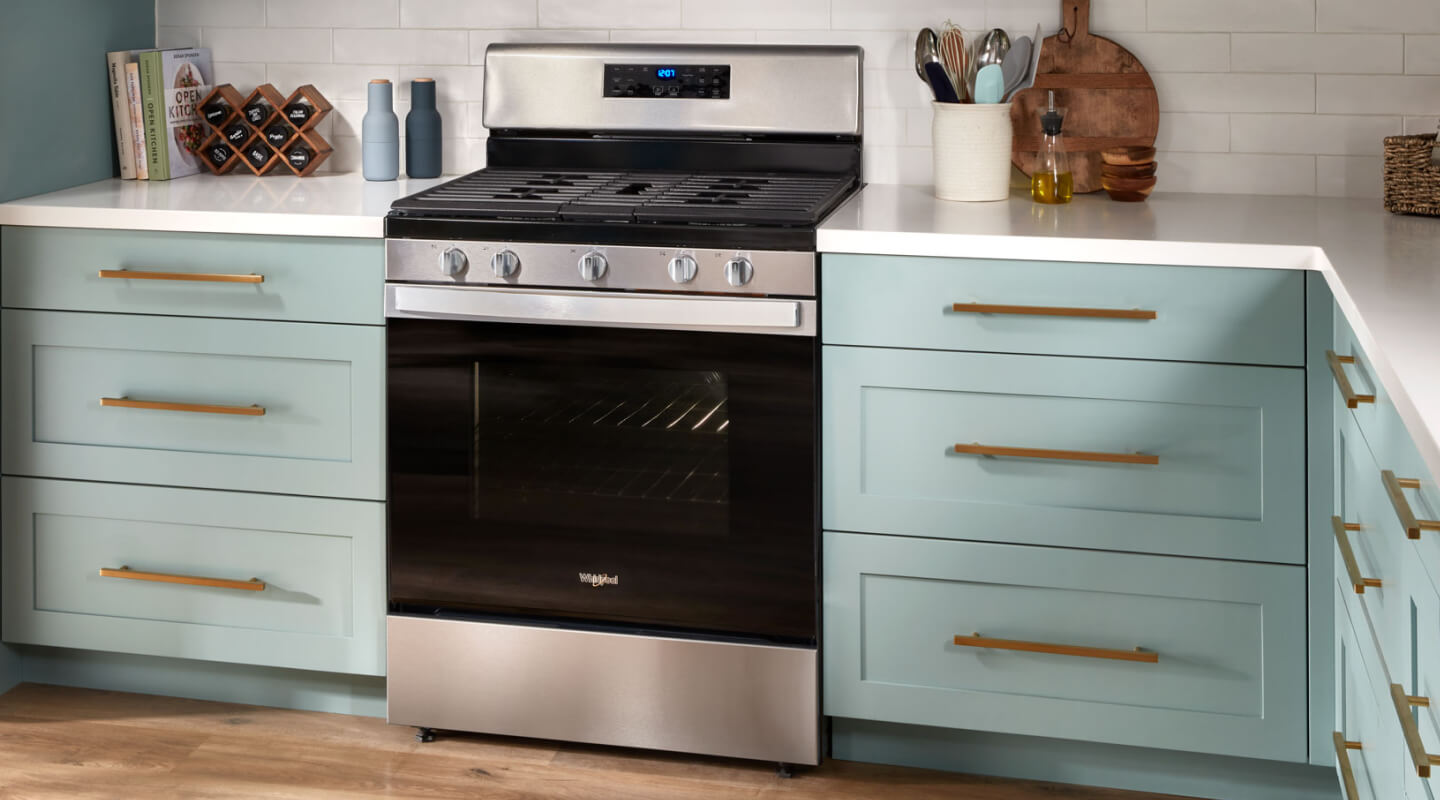 A Whirlpool® oven in a modern kitchen with blue cabinetry.