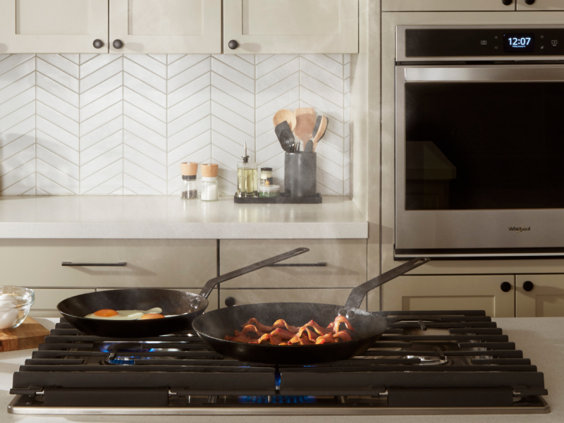 Pans cooking food on a Whirlpool® cooktop Pans cooking food on a Whirlpool® cooktop