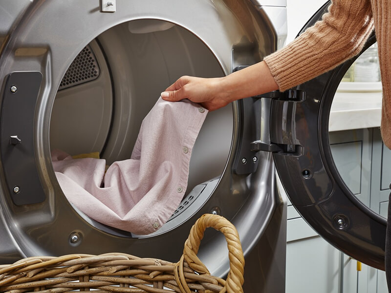 Person removing clothes from a dryer