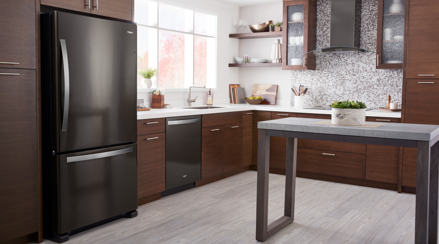 A black Whirlpool® Bottom-Freezer Refrigerator in a modern kitchen