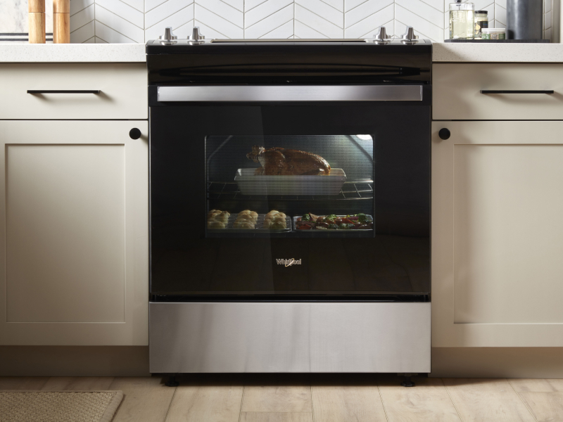 A chicken dinner roasting in an oven