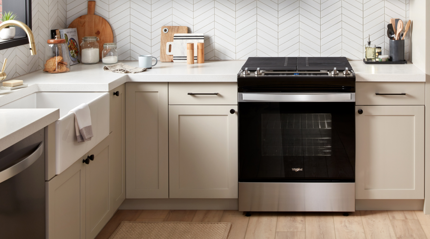 Black Whirlpool® gas range in tan cabinetry