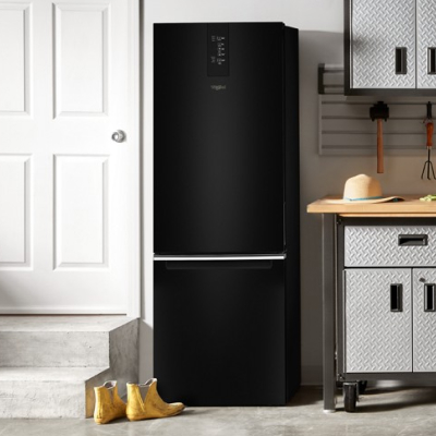 Black bottom-freezer refrigerator in garage