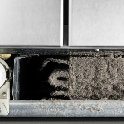Close-up of lint on refrigerator condenser coils