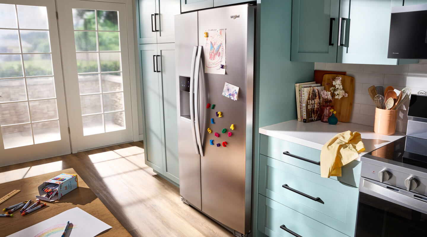 Stainless steel side-by-side refrigerator in light blue cabinetry