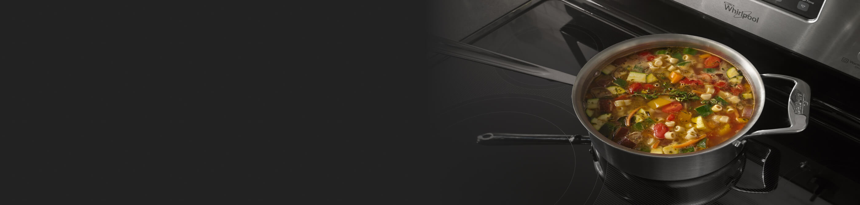 A stew of vegetables, herbs and pasta cooking on a burner