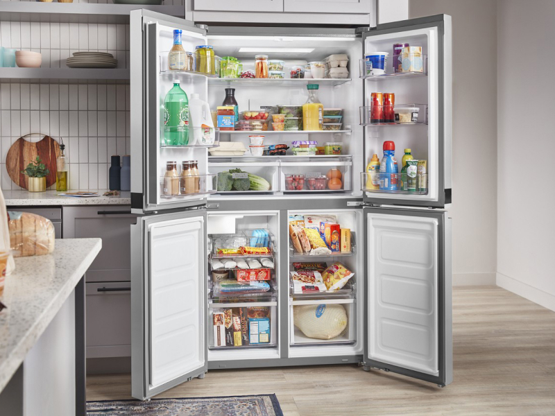 Open four door refrigerator full of groceries