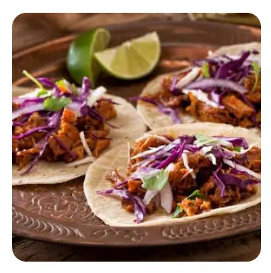 Three pork tacos with purple cabbage and lime