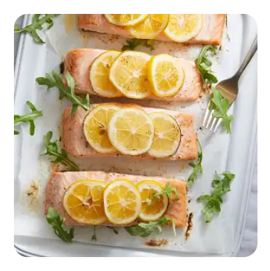 A platter of salmon filets with sliced lemons and arugula