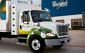 Front cab of semi truck in front of a Whirlpool Corporation building