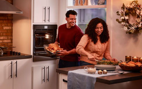 People preparing dinner fixings in a single wall oven