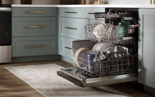 A dishwasher sitting next to teal cabinets in a kitchen