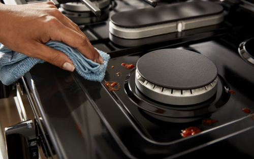 Person wiping a stovetop