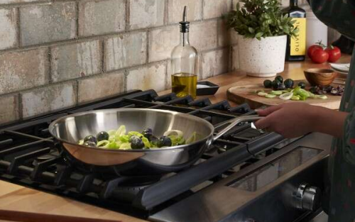 Person cooking broccoli in a pan