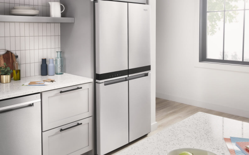 A stainless steel 4-door fridge in a bright kitchen