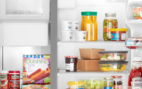 Various food items and beverages stored in a side-by-side refrigerator