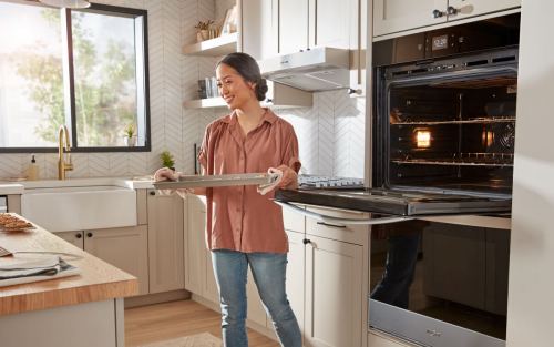 A person removing a tray from the oven