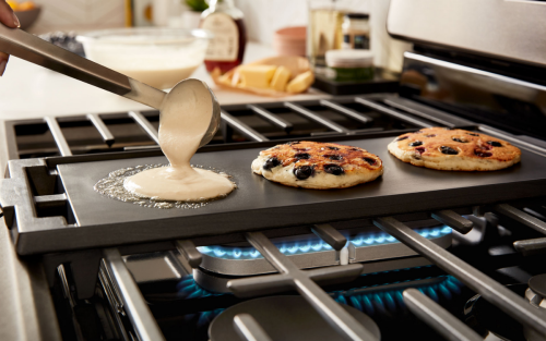 Pancakes cooking on a stovetop griddle