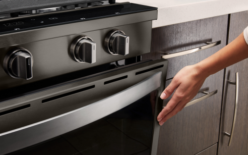 Person closing an oven door