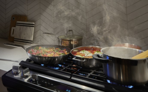 Various dishes cooking on the cooktop of a gas range