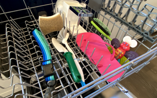 Dog collar, dish scrub brush and a sponge inside a dishwasher