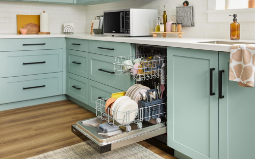 Open dishwasher filled with clean dishes between light blue cabinets