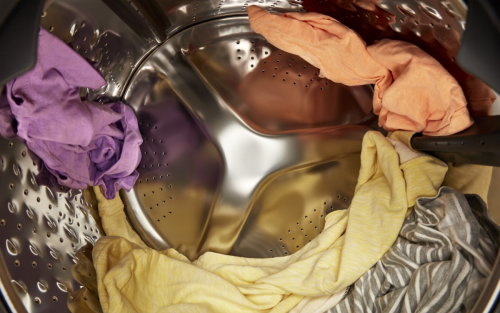 Brightly colored clothing spinning in a dryer