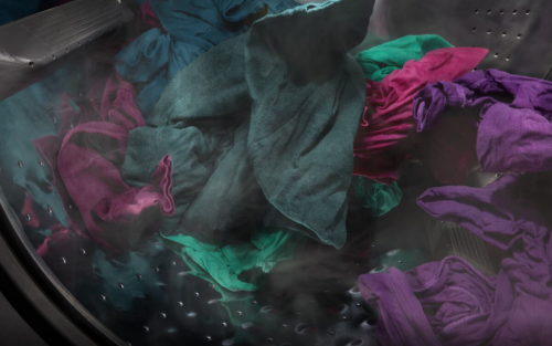 Dark purple and green clothes spinning in a washer