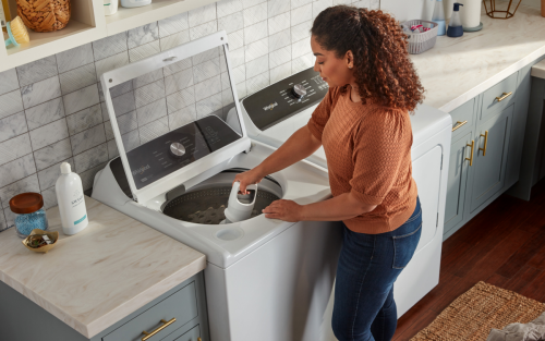  Person removing agitator from Whirlpool® 2-in-1 washing machine