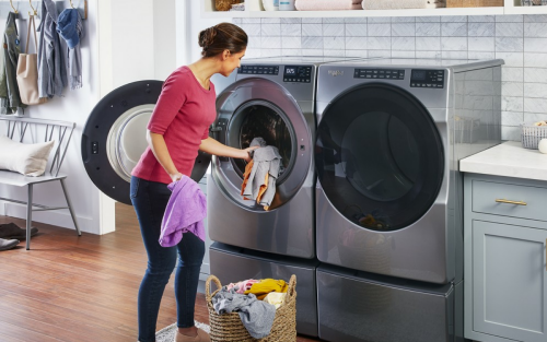 Woman loading clothing into front-load washer